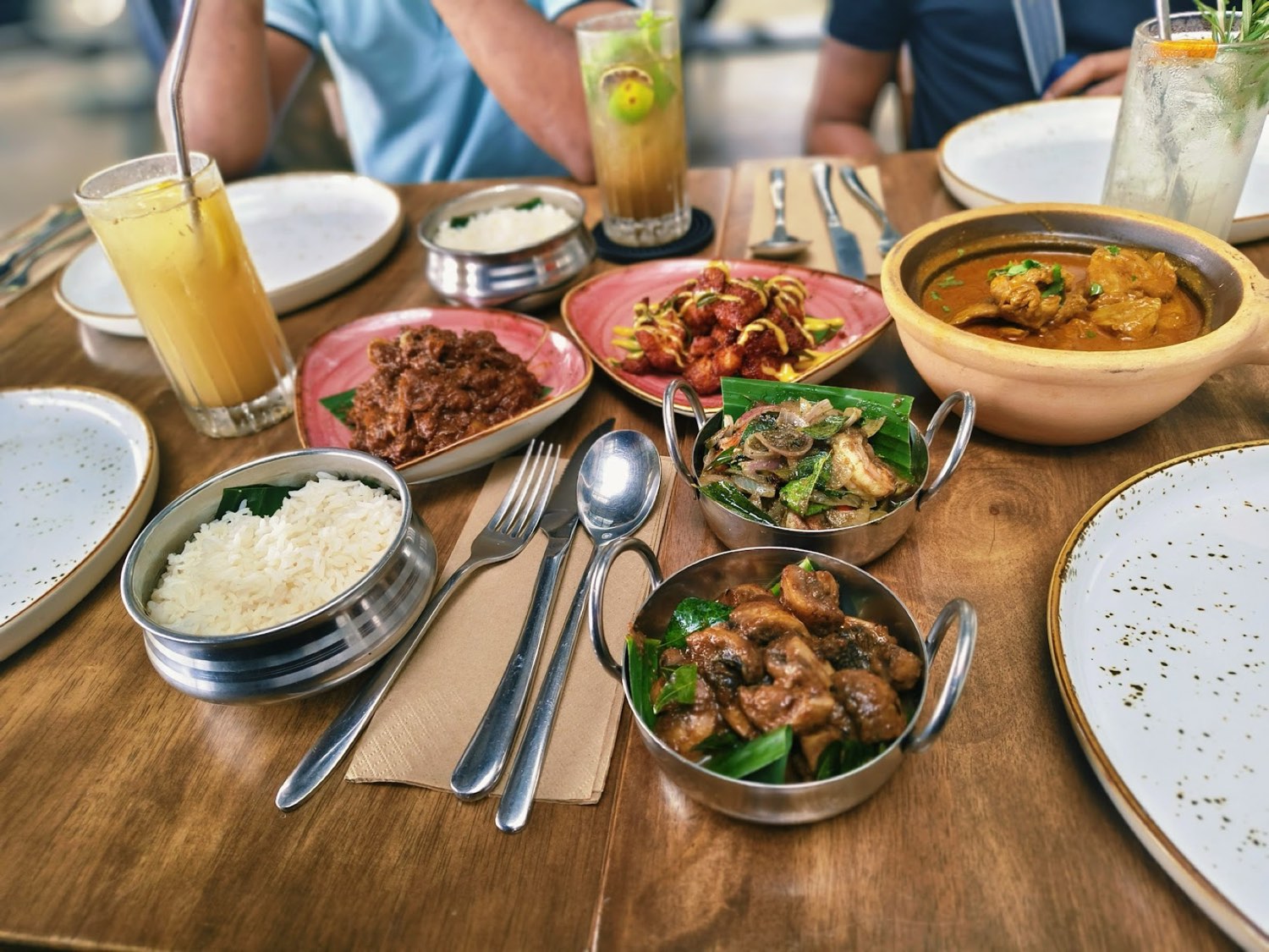 A spread of South Indian dishes with chicken varuval, curries and mocktails