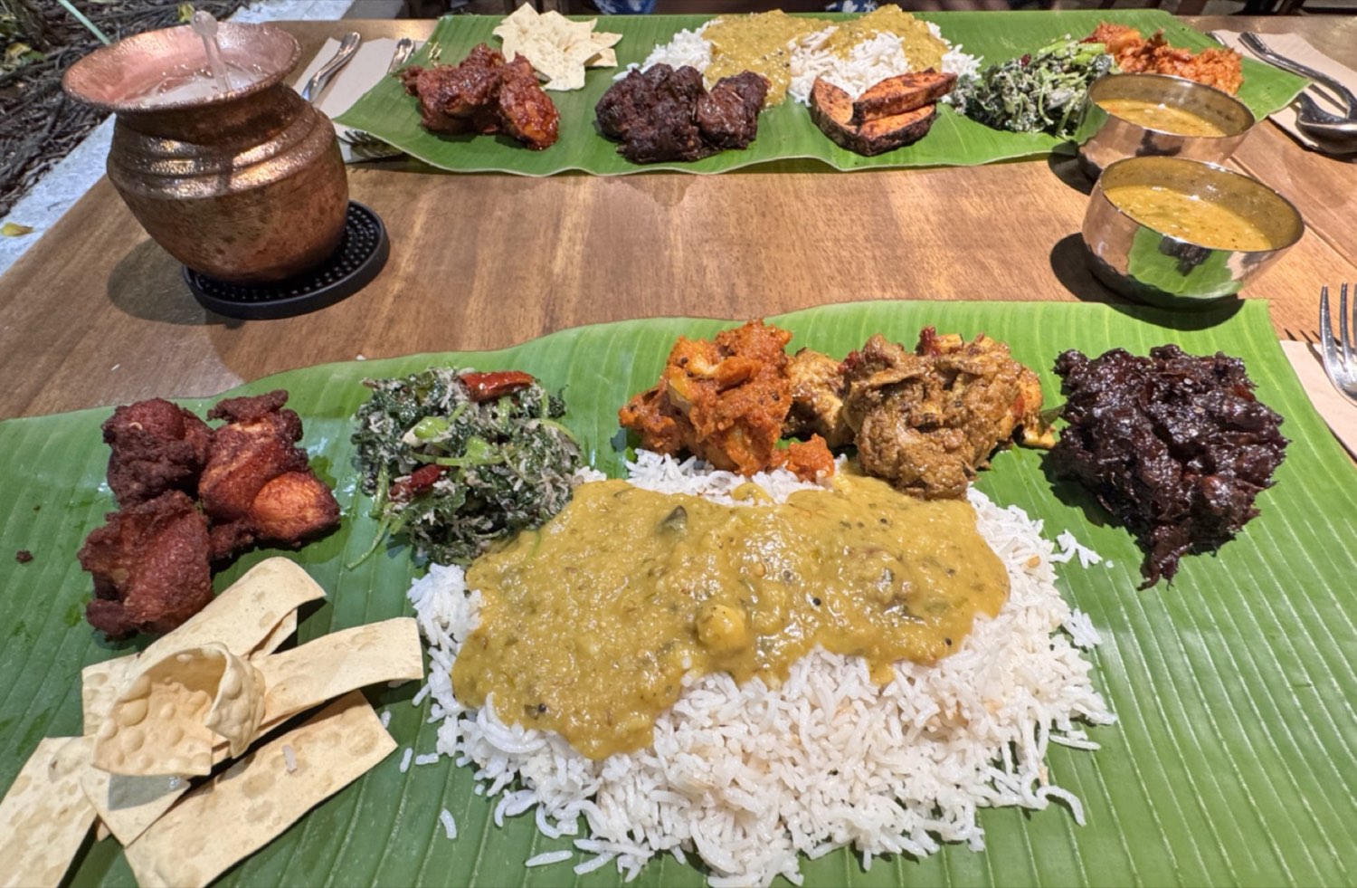 Banana-leaf feast with rice, dhal, varuvals and side dishes laid out